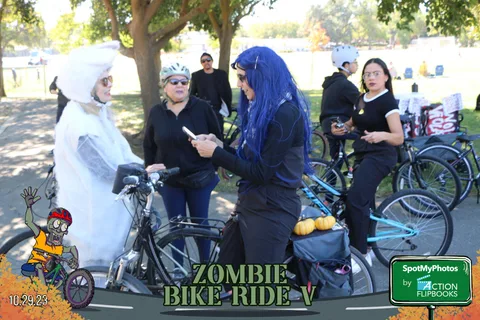 Two people in ghost-themed costumes shake hands at the festival.