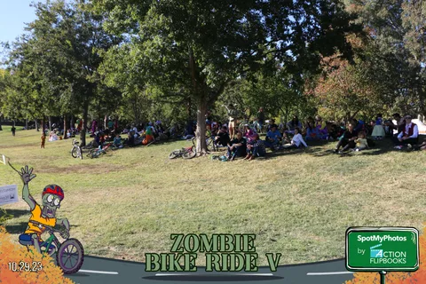 A wide, mostly empty view of the grassy festival field with distant people and bikes.
