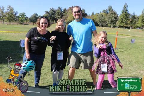 A family of three waves and smiles together at the festival.
