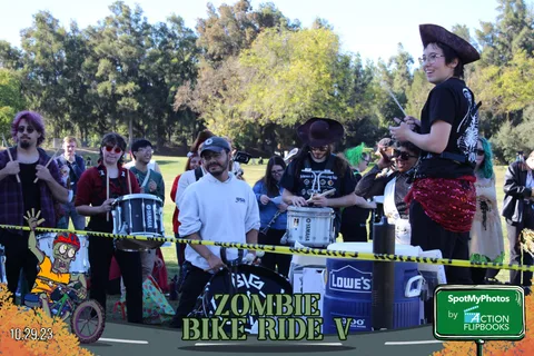 A costumed drumline performs together at the Zombie Bike Ride finish line.