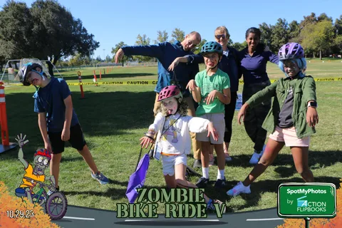 A costumed family group jumps and poses together outdoors.