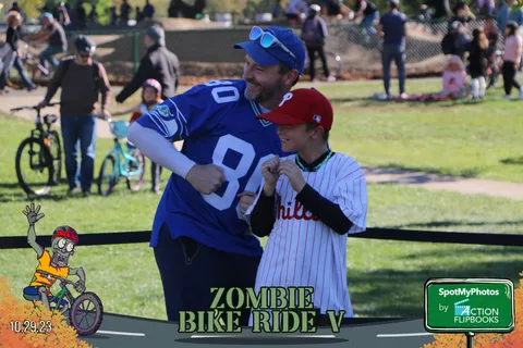 A man and boy in baseball jerseys share a fist bump at the festival.