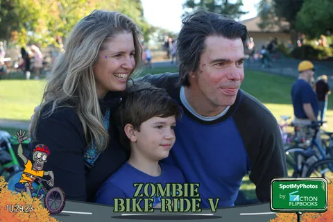 A mother, father and young son smile together in the park.