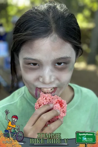 A child eats a messy pink dessert in close-up.