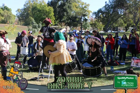 A crowd of costumed festival-goers gathers near the vendor tents.