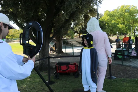 A staff member adjusts lighting for a child at the photo booth.