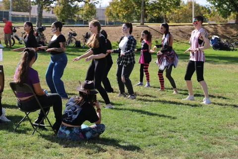 Dancers in coordinated outfits perform in a line at the festival.