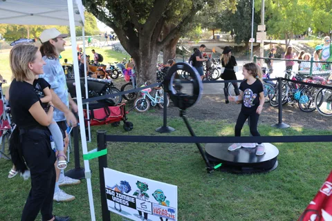 Festival-goers try a balance game at an activity booth.