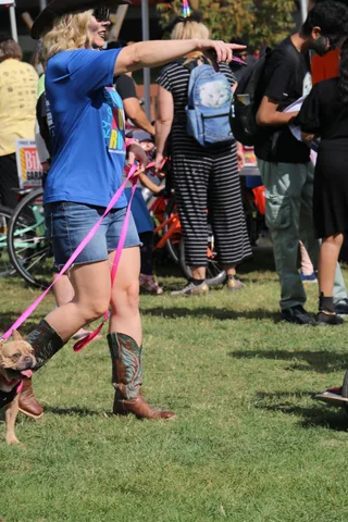 A woman adjusts her wig while walking through the festival crowd.