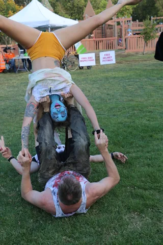 An acrobat holds a full mid-air side split during the stage show.