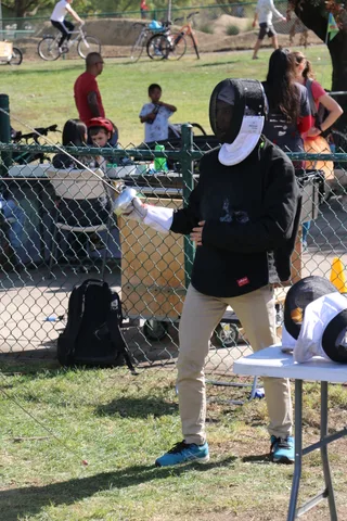 A man draws back a bowstring at the archery booth.