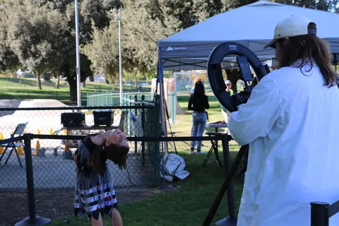 A girl moves quickly near the photo booth, blurring with motion.
