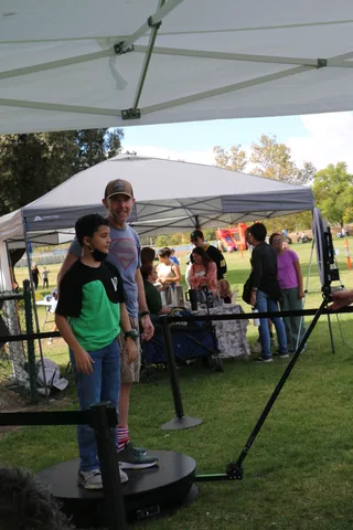 Two festival-goers high-five near the entrance tent.