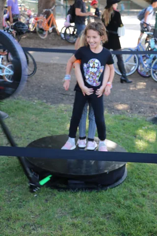 A girl poses on a spinning photo platform near the bike corral.