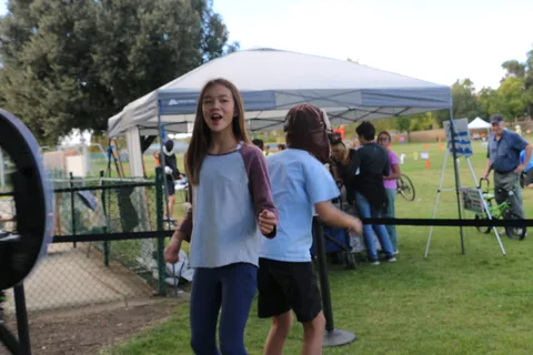 Two teens walk across the festival's photo booth platform.