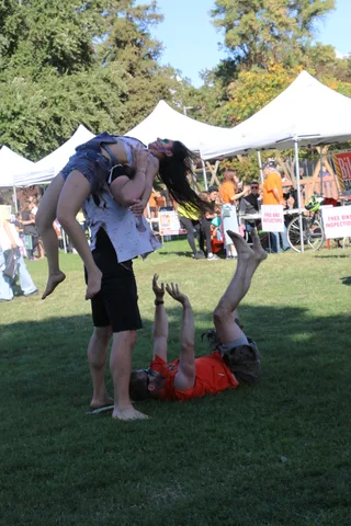 A zombie-painted performer lifts a limp companion overhead during the stage show.