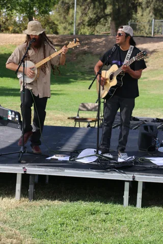 Two musicians play banjo and guitar for the festival crowd.