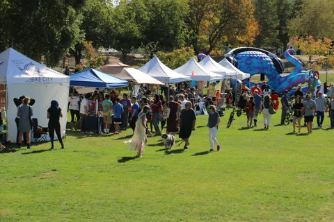 A wide crowd of festival-goers mills among the vendor tents.