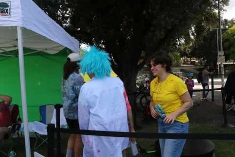 Festival-goers gather near the green screen photo booth setup.