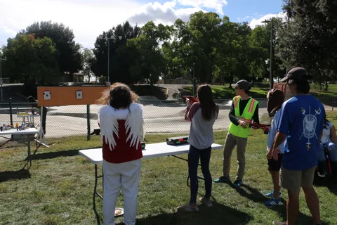 A person faces away from the camera at a park booth with a target sign.