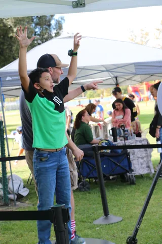 A man and a boy raise their arms in celebration at the festival.