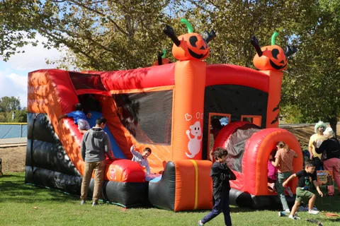 Kids play on a pumpkin-themed bounce house at the festival.
