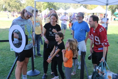 A family group poses together, including kids in Halloween costumes.