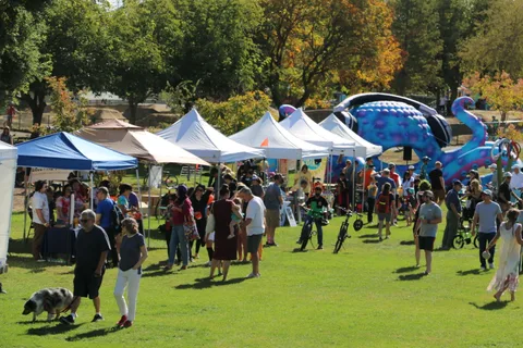 Festival attendees walk among rows of vendor tents.
