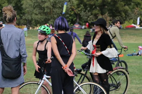 Two women in pirate-style costumes stand with their bikes.