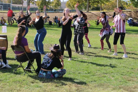 Kids watch a costumed dance group perform at the festival.