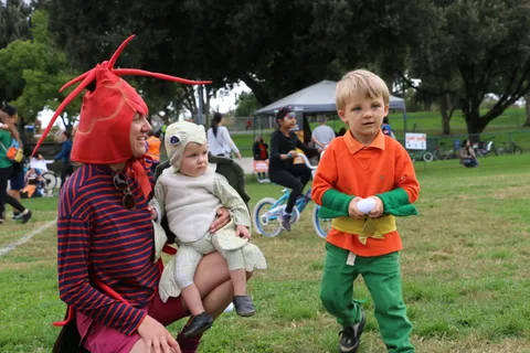 A family gathers together as a boy rides up on his bike.