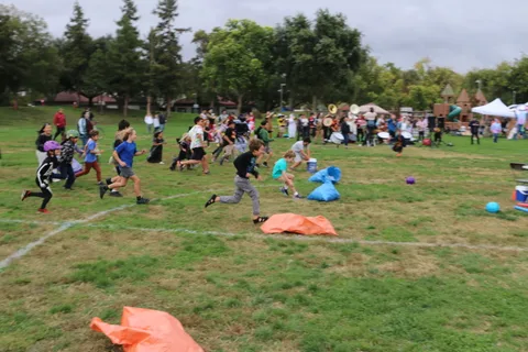 Costumed kids run across the field during the ball-toss game.