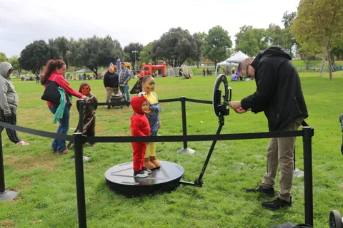 An attendant operates the spinning platform ride as a child rides.