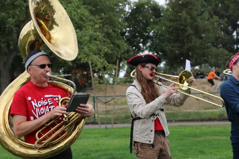 A sousaphone and trombone player perform mid-song.