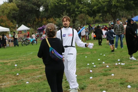 A woman and a person in an astronaut costume face each other during the game.