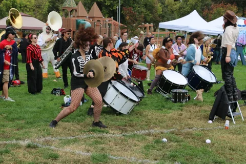 A drummer raises her cymbal mid-strike as the line performs.
