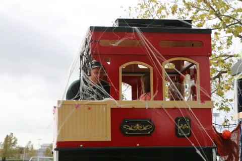 A red trolley car sits wrapped in decorative spiderwebs.