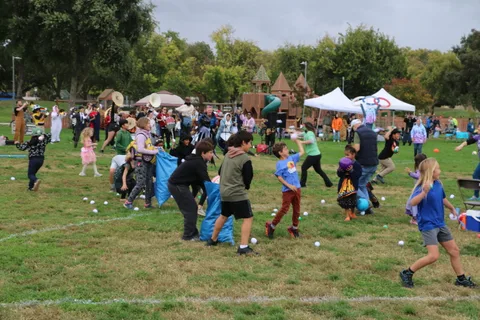 Kids run across the field as the ball-toss game continues near the tents.
