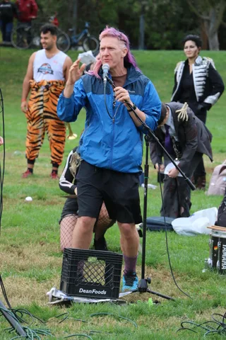 Dancers in tiger-striped leggings perform near sound equipment, cropped at the waist.