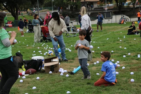 A crowd of festival-goers gathers near the lawn game area.