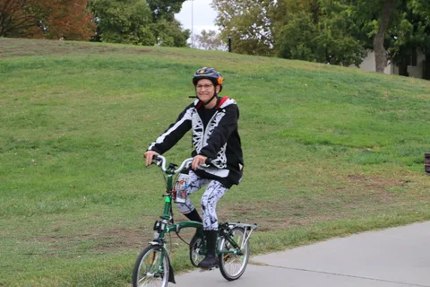 A woman in a skeleton-patterned outfit rides alone.