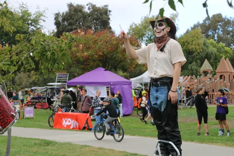 Two people in face paint costumes engage playfully with the camera together.