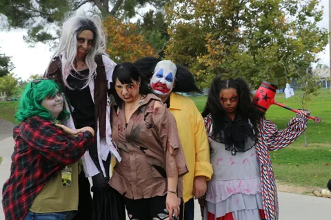 A group of costumed zombie and clown performers stand together.