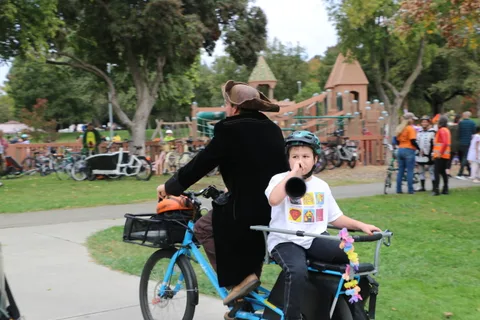 A child rides a decorated bike near a playground castle structure.