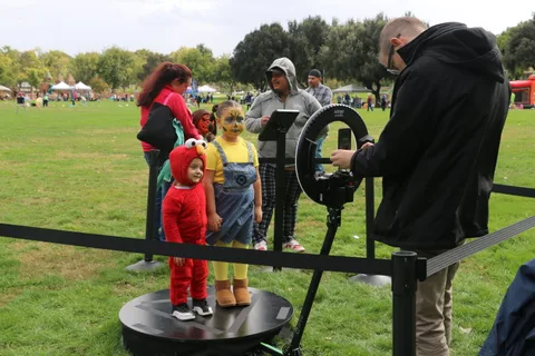 Two children in matching bug costumes wait at the spinning ride.