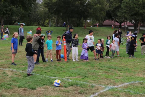 A crowd of costumed kids and families gathers near the tents.