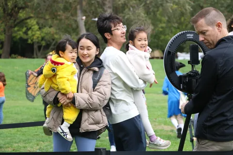 A mother and father pose with their daughter dressed as a chick for a family photo.