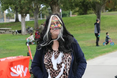 A woman with elaborate zombie skull makeup poses in leopard print at the festival.