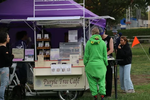 People visit the Purple Tree Cafe booth at the festival.
