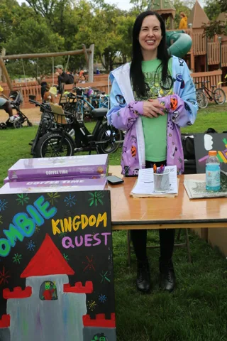 A sign for the Zombie Kingdom Quest activity sits on a table at the festival.